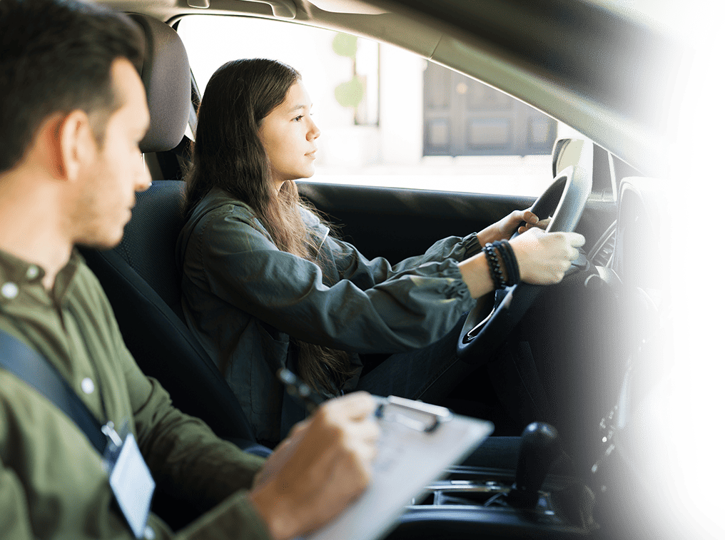 A man and woman in the driver's seat of a car, preparing for a driving test in Texas.