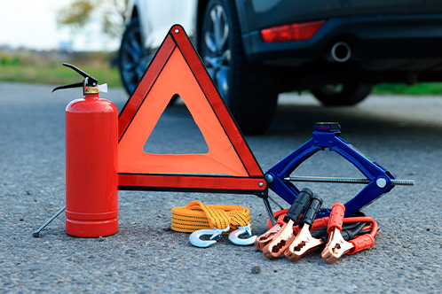 A vehicle showing a fire extinguisher, tools, and an accident warning sign, highlighting Texas road safety essentials.