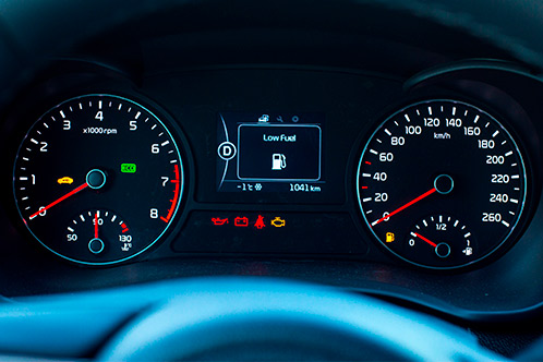 Car dashboard featuring gauges and a speedometer, emphasizing key maintenance advice for Texas teen drivers.