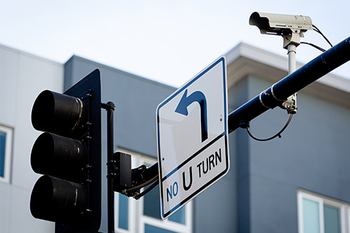 A traffic light and street sign displaying U-turn regulations, essential information for new Texas drivers.