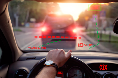  A driver in a car, looking ahead, with a red warning light glowing on the dashboard, indicating a potential issue.