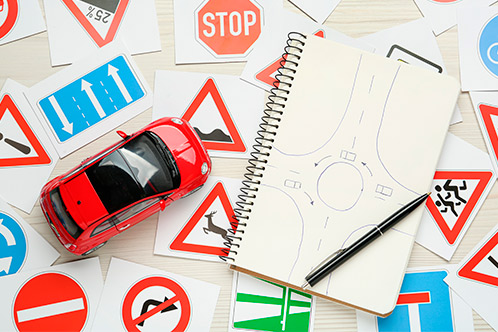 A notebook with a small car placed on it, representing guidance for those who failed the Texas DPS Written Exam.