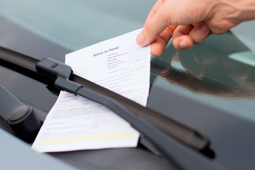 transportation and vehicle concept - parking ticket on car windscreen