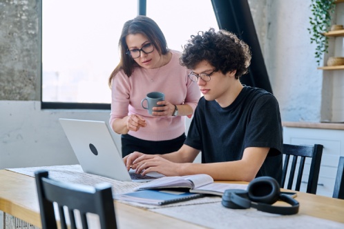 Middle aged mother and son university student, together at home